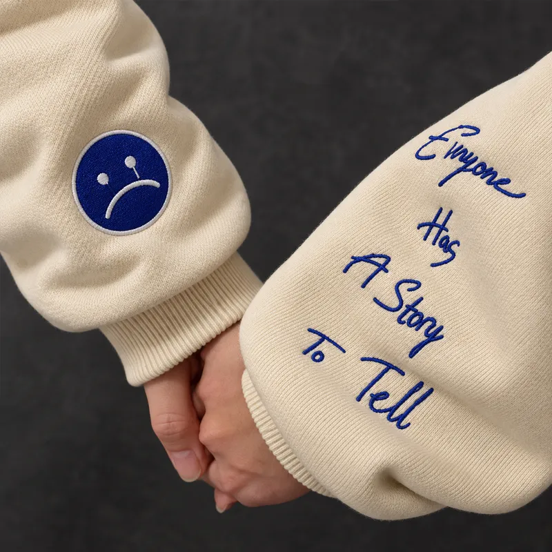 Cream sweatshirts with blue custom logo embroidery and sleeve script